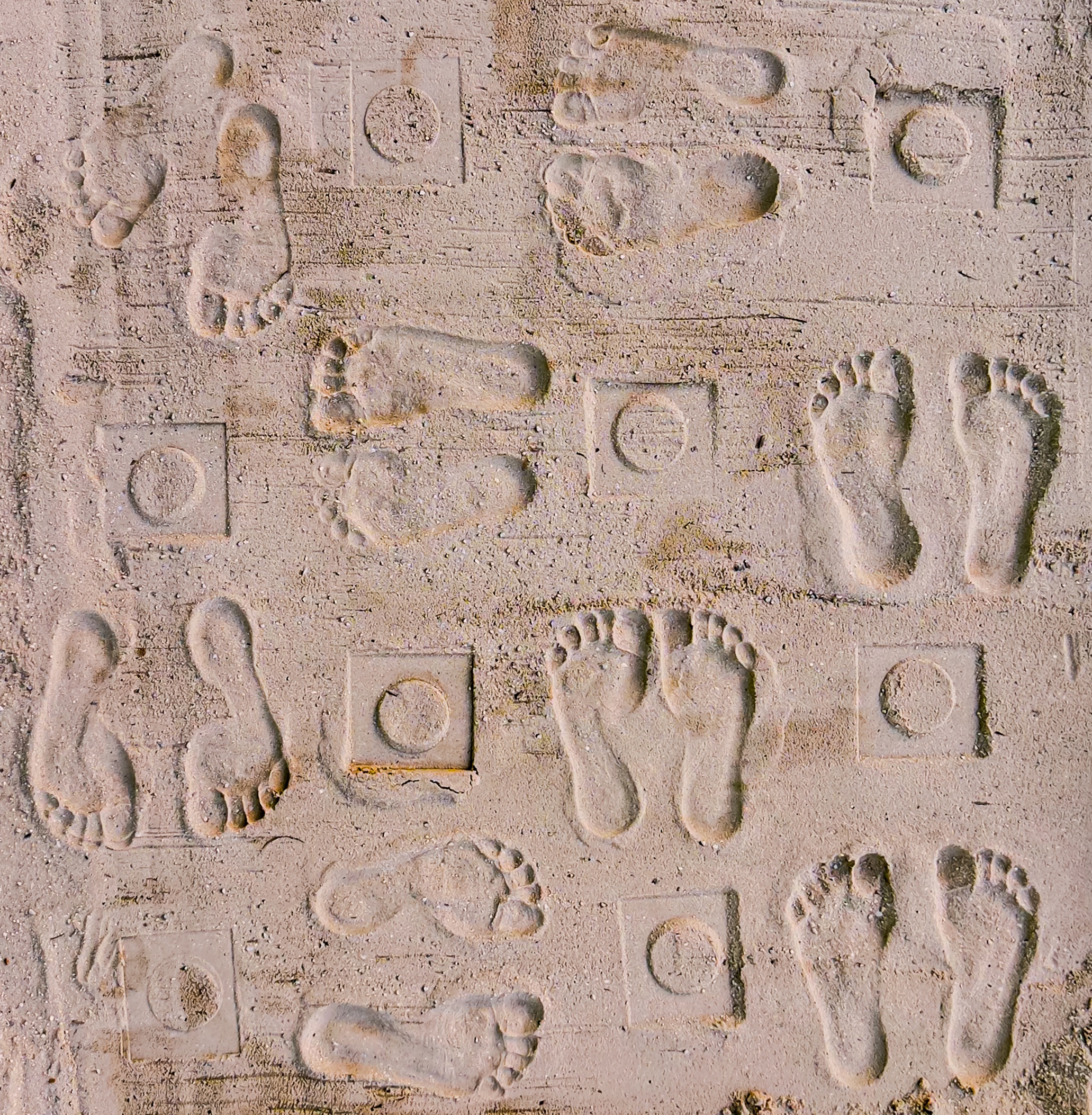 Footprints and Lifeform impressions pressed into sand.